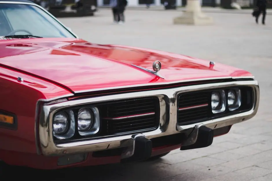 Detailed close-up of a vintage red Dodge Charger front, parked outdoors.